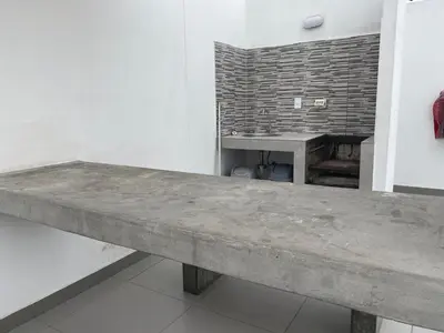 a concrete bench in a room with a table at Life is better by the sea in Lima