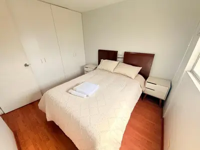 a small bedroom with a bed and two night stands at Casa Lima Brasil in Lima