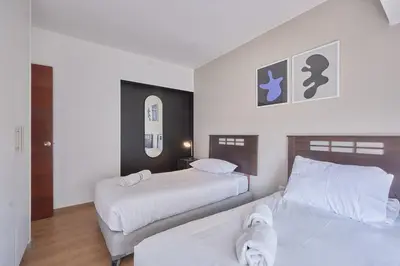 a bedroom with two beds with white sheets at Barranco Bright apartment with Balcony in Lima