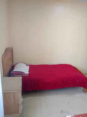 a bed in a room with a red blanket at San Juan in Lima
