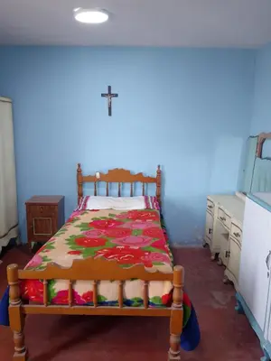 a bedroom with a wooden bed with a colorful blanket at San Juan in Lima
