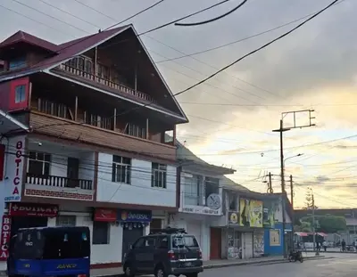 a building on the side of a street with cars parked at Oxapampa Center Room- habitacion centro in Oxapampa