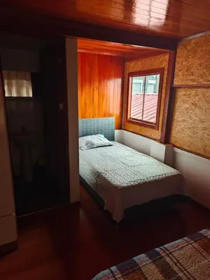 a small bedroom with a bed and a window at Oxapampa Center Room- habitacion centro in Oxapampa