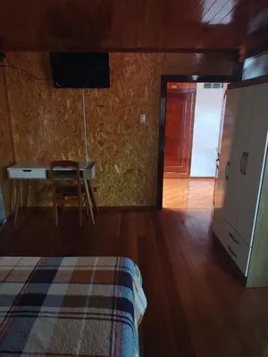 a bedroom with a bed and a desk and a table at Oxapampa Center Room- habitacion centro in Oxapampa