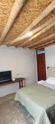a bedroom with a bed and a wooden ceiling at Descanso del Guerrero - PARACAS in Paracas