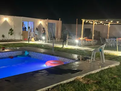 a swimming pool in a yard at night at Descanso del Guerrero - PARACAS in Paracas