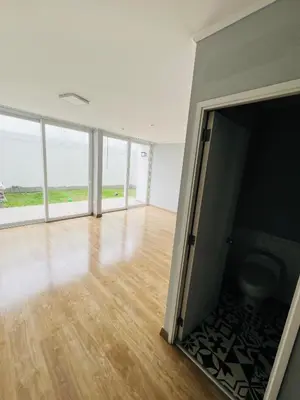 an empty room with wooden floors and large windows at El Derby in Lima