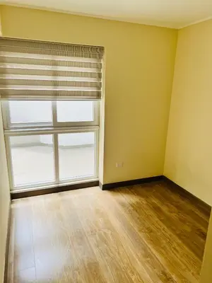 an empty room with a large window and a wooden floor at El Derby in Lima