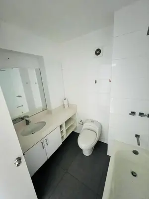 a white bathroom with a toilet and a sink at El Derby in Lima