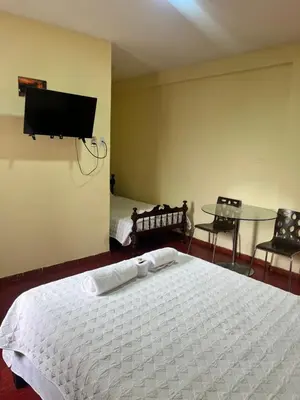 a bedroom with a bed and a table and a tv at La Finca de la Norteñita 1926 in Santa Rosa de Quives