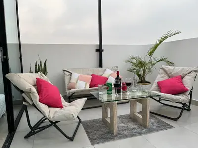 a living room with two chairs and a glass table at Albano Penthouse íntimo piscina y vista al mar in Lima