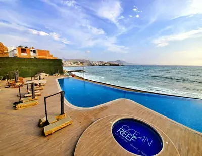 a swimming pool with the ocean in the background at Condominio Ocean Reef Playa Norte San Bartolo in San Bartolo