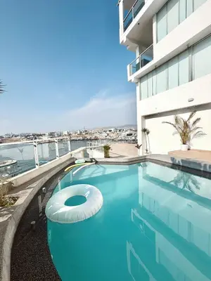 a swimming pool in front of a building at Infinitive view San Bartolo in San Bartolo