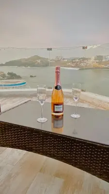 a bottle and two wine glasses sitting on a table at Infinitive view San Bartolo in San Bartolo