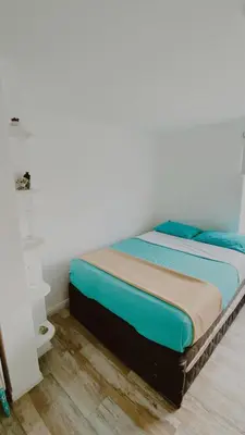 a bedroom with a bed with blue sheets on it at Infinitive view San Bartolo in San Bartolo