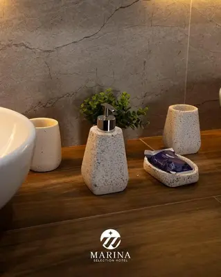 a bathroom with a sink and three soap dispensers on a counter at Marina Selection Hotel in San Juan de Marcona