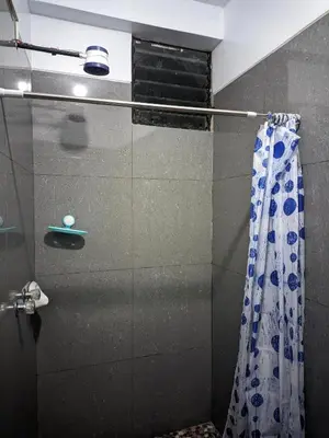 a shower with a glass door and a shower curtain at Aguilar Apaza Family in Machu Picchu