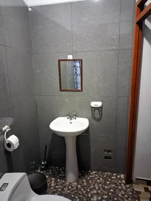 a bathroom with a sink and a toilet and a mirror at Aguilar Apaza Family in Machu Picchu