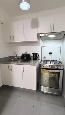 a kitchen with white cabinets and a stove top oven at Pueblo Libre 501 in Lima