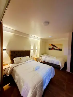a hotel room with two beds with white sheets at MAR y LAGO EXPERIENCE in Lunahuaná