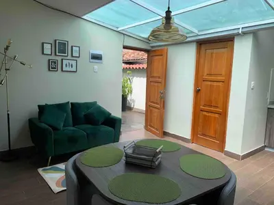 a living room with a green couch and a table at Full Mini Apartment for 2 in Cusco