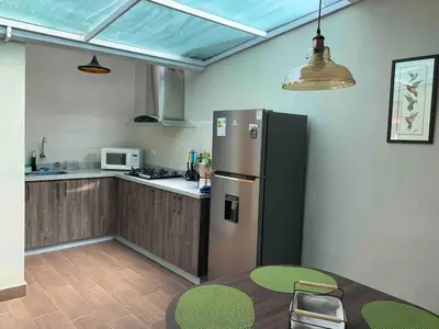 a kitchen with a stainless steel refrigerator and a table at Full Mini Apartment for 2 in Cusco