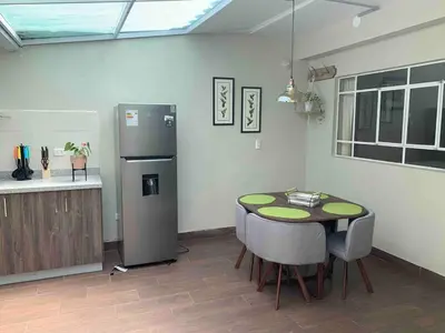 a kitchen with a table and a refrigerator at Full Mini Apartment for 2 in Cusco