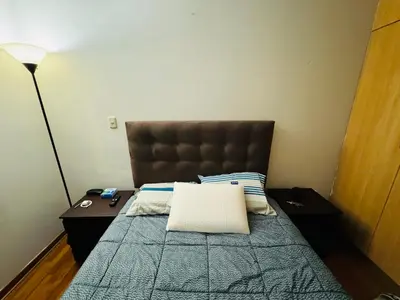 a bedroom with a bed with a brown headboard at Kira House in Lima