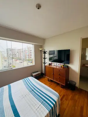 a bedroom with a bed and a flat screen tv at Kira House in Lima