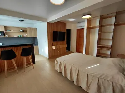 a bedroom with a bed and a tv and some chairs at Matrix Alojamiento in Punta Negra