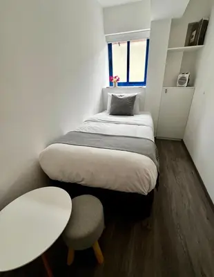 a bedroom with a bed and a table and a chair at Acogedor Departamento en Centro Histórico de Cusco in Cusco