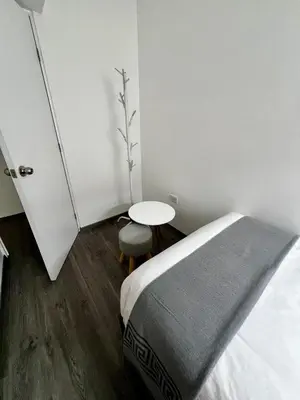 a bedroom with a bed and a small table at Acogedor Departamento en Centro Histórico de Cusco in Cusco