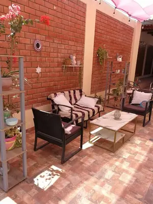 a patio with chairs and tables and a brick wall at Large quiet apartment in condominium in Santa Eulalia