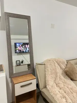 a living room with a couch and a mirror at Departamento de un solo ambiente in Lima