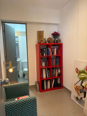 a room with a red book shelf with books at Beautiful brand new apartment for rent in Lima
