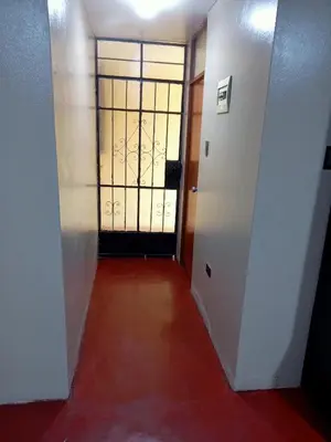 a hallway with a door and a red floor at Departamento 3 dormitorios 4A in Lima