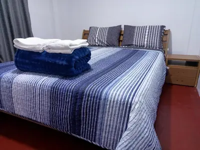 a bed with blue and white striped sheets and pillows at Departamento 3 dormitorios 4A in Lima