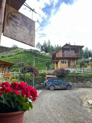 a car parked on a road in front of a house at Lodge La Arboleda - Oxapampa in Oxapampa
