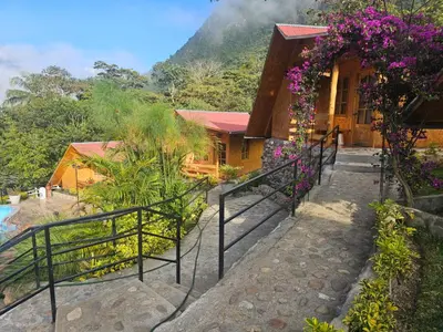 a house with flowers in front of it at Lodge La Arboleda - Oxapampa in Oxapampa