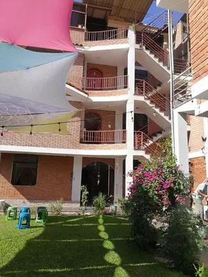 an apartment building with a yard with a building at Departamento tranquilo en Condominio in Santa Eulalia