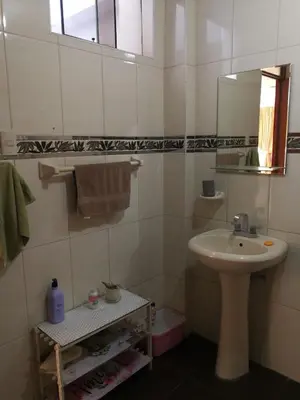 a white bathroom with a sink and a mirror at Departamento tranquilo en Condominio in Santa Eulalia
