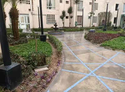 a walkway in a courtyard with a fountain and palm trees at Costa 21 Frente al Mar San Miguel in Lima