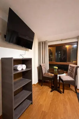 a living room with a table and a tv in a room at Hospedaje chakana inn in Cusco