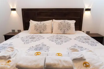 a bedroom with a bed with white sheets and pillows at Lama Vista Living 401 in Cusco