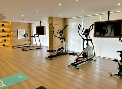 a gym with several exercise bikes and a flat screen tv at Departamento de Estreno en Zona Financiera in Lima