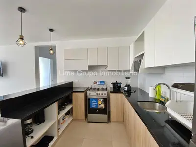 a kitchen with white cabinets and a black counter top at Duplex Condominio Míkonos Asia in Asia