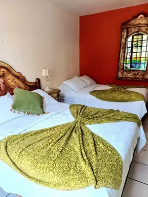 two beds in a room with red walls at Hostal Sol Y Luna - Cieneguilla in Cieneguilla