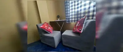 two gray chairs with red pillows sitting in a room at Nazcazone in Nazca