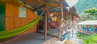 a hammock on the outside of a house at Albergue Salkantay Chawllay in Santa Teresa
