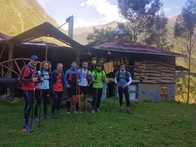 a group of people posing for a picture in front of a cabin at Albergue Salkantay Chawllay in Santa Teresa